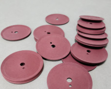 Pink cup-shaped discs with central and smaller offset holes.