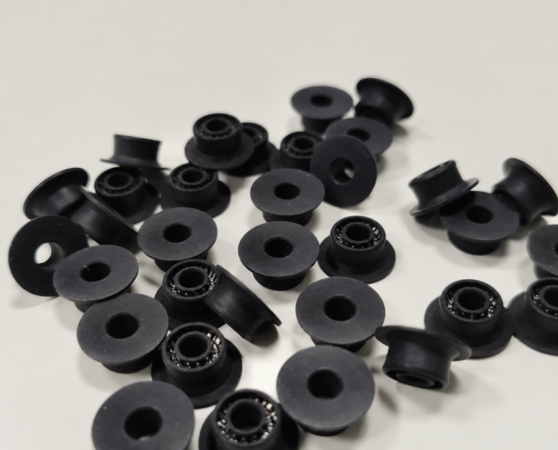 Chromatography pump plunger seals Black flanged seals, some showing metal spring elements around their central openings.