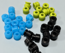 Blue, yellow-green and black spool-shaped seals with central openings.