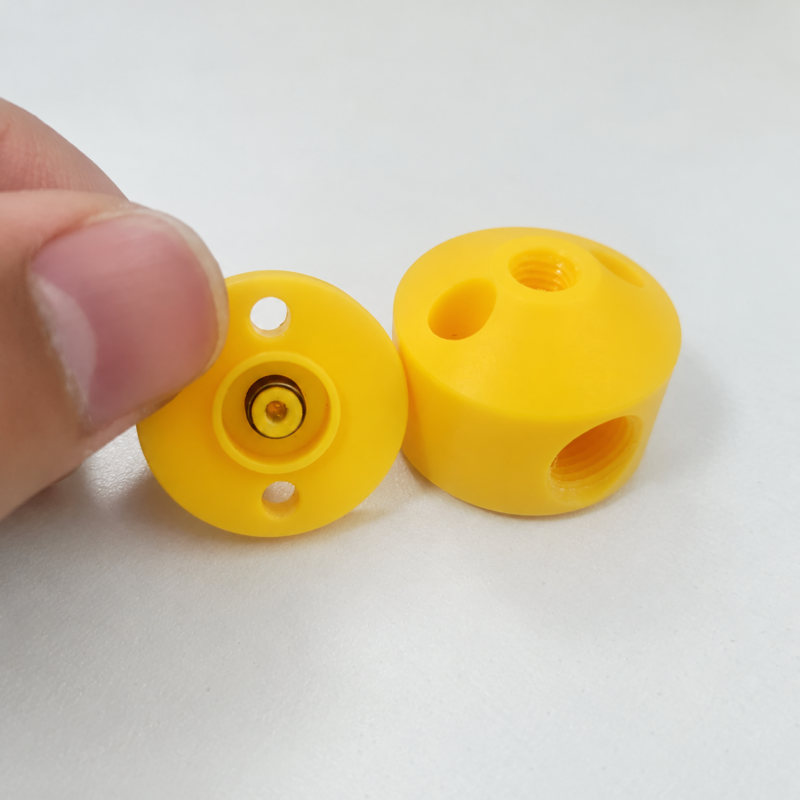 UHMWPE diaphragm dispensing valve parts Yellow cylindrical valve body and round diaphragm component with mounting holes.