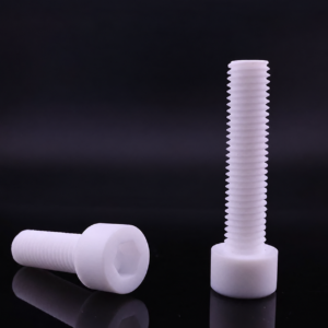 Two white IKSONIC PTFE socket-head screws on a dark reflective surface, one horizontal with its hexagonal socket visible and one upright.
