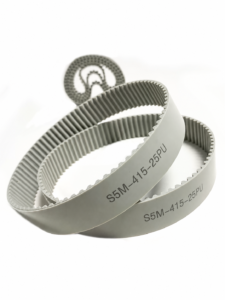 Grey S5M polyurethane timing belt profile example with two overlapping loops marked S5M-415-25PU and a blurred rolled belt behind — IKSONIC manufacturing range.
