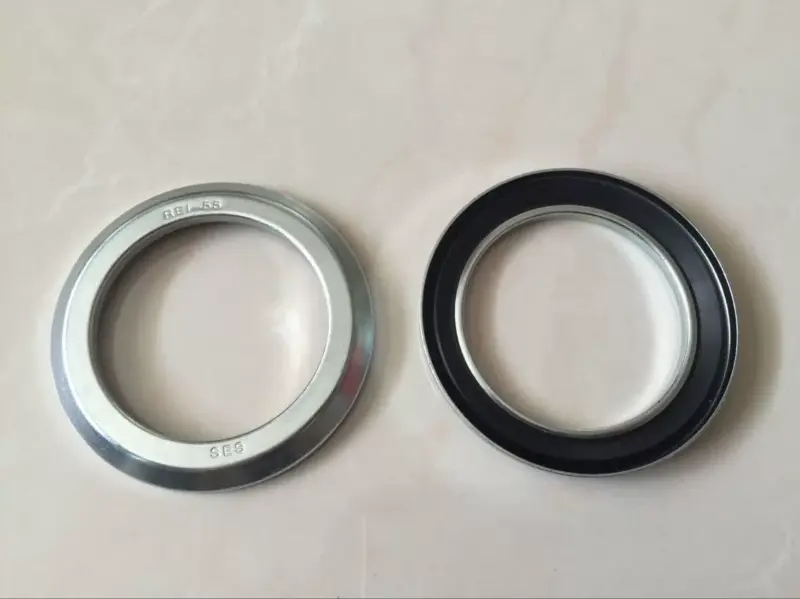 IKSONIC-ses-re-motor-oil-seals-front-and-back-main Front and back views of SES-branded RE motor oil seals supplied by IKSONIC, showing a silver metal face and black sealing lip.