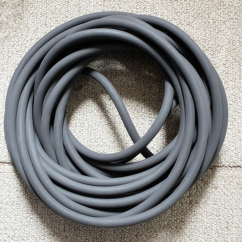 Dark round-section O-rings nested together on a textured pale surface.
