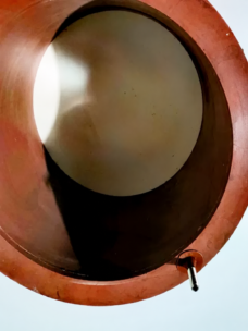 Close-up of an orange-brown annular inflatable seal with a metal inflation stem.