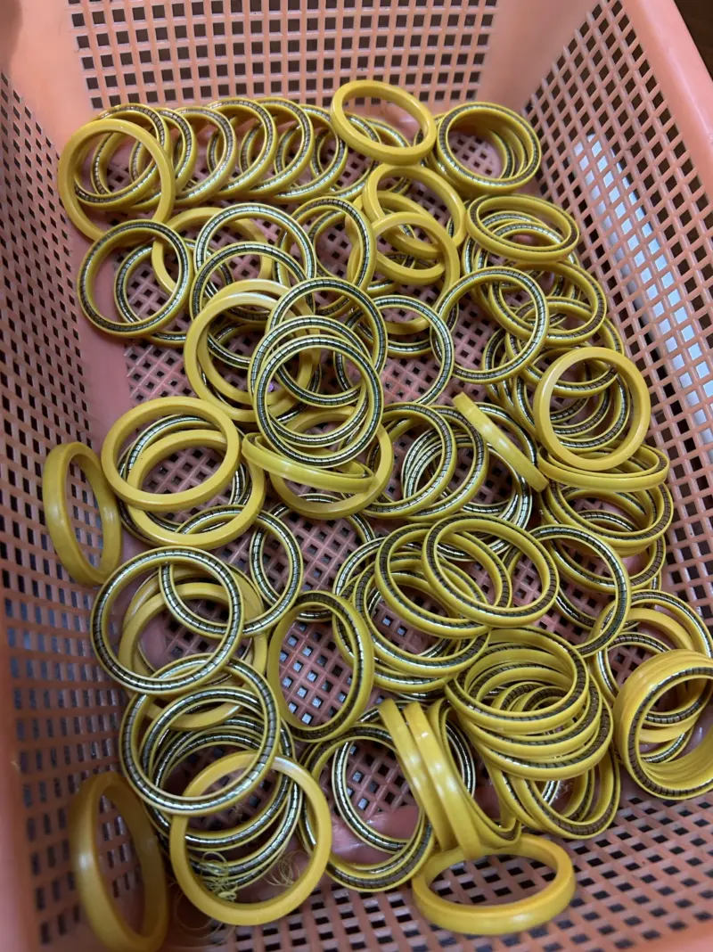 Imported Double-Spring LNG Filling Nozzle Seals Yellow sealing rings with visible metal springs piled in a pink basket.