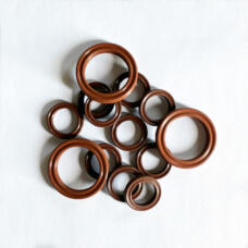 Assorted small brown grooved sealing rings overlapping on a white surface.