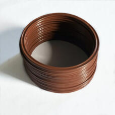Stack of brown sealing rings viewed at an angle on a white surface.