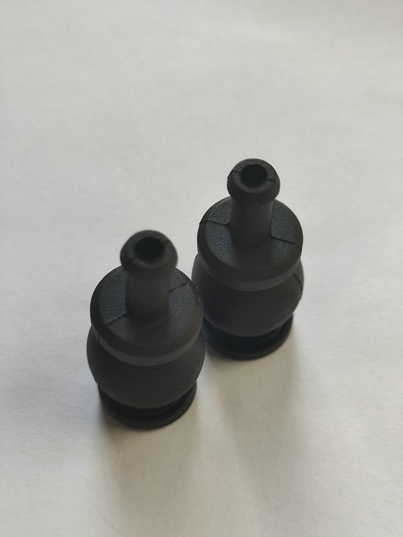 Top view of two black damping balls showing hollow mounting stems