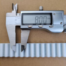 White IKSONIC timing belt sample beside a digital caliper displaying 8.00 mm.