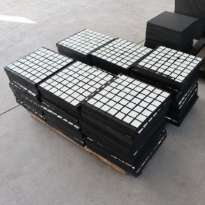 Six stacks of IKSONIC square-tile ceramic rubber liner panels on a pallet.