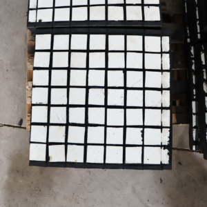 Close view of white square ceramic tiles and black joints on an IKSONIC liner panel.