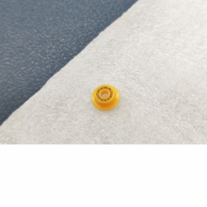 Supplier photograph of one yellow analyzer plunger seal from an angled front view on a white cloth.