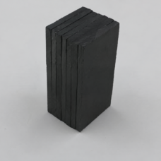 Stacked dark rectangular IKSONIC ceramic liner tiles showing their edges and surface texture.