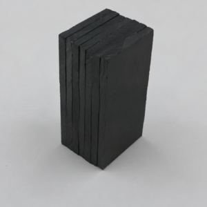 Stacked dark rectangular IKSONIC ceramic liner tiles showing their edges and surface texture.
