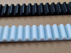 Black and white IKSONIC timing belt samples showing rounded tooth profiles and visible cord lines.