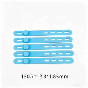 Five IKSONIC blue silicone cable ties with fastening studs and adjustment slots, showing dimensions of 130.7 × 12.3 × 1.85 mm.