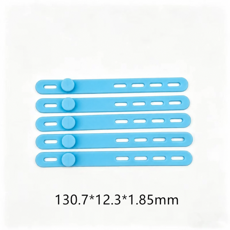 Five IKSONIC blue silicone cable ties with fastening studs and adjustment slots, showing dimensions of 130.7 × 12.3 × 1.85 mm.