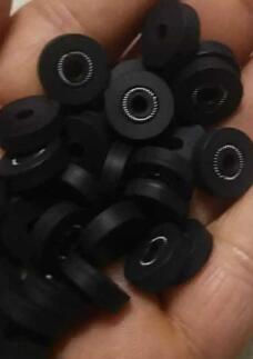 A handful of small black flanged seals with visible circular metal springs; supplied by IKSONIC in China.