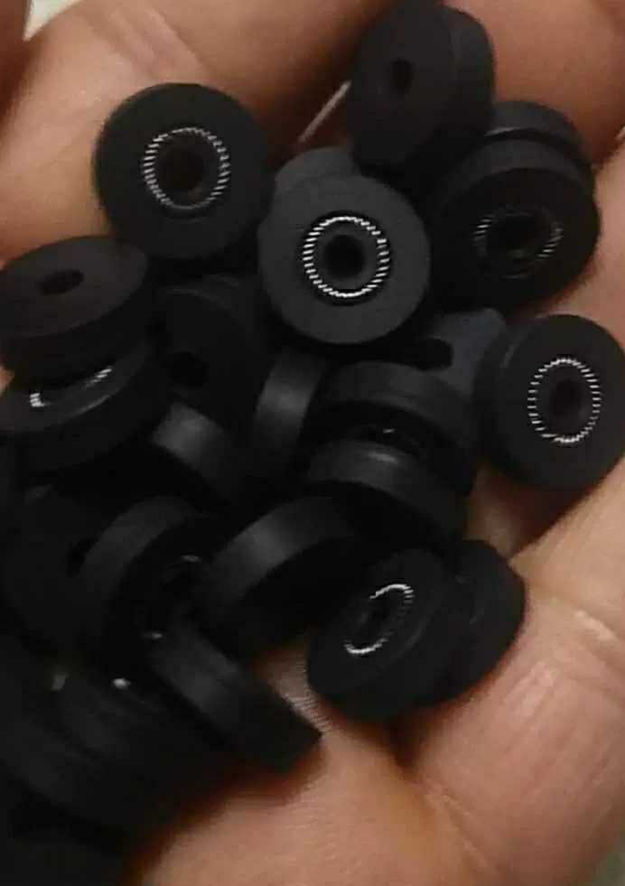A handful of small black flanged seals with visible circular metal springs; supplied by IKSONIC in China.