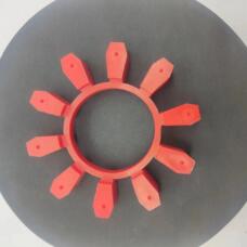 Top view of a red ten-lobe coupling insert on a dark circular surface; supplied by IKSONIC in China.