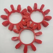 Three red coupling inserts with rectangular radial lobes arranged on a white surface; supplied by IKSONIC in China.