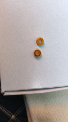 Two small yellow annular seals on a pale surface; supplied by IKSONIC in China.