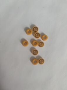 Small yellow annular pump seals on a pale surface, showing plain faces and exposed metal springs; supplied by IKSONIC in China.