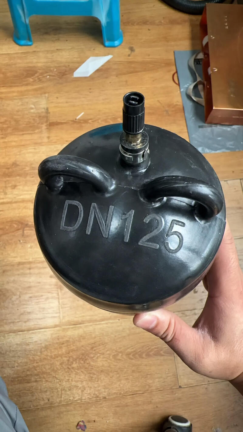 Close-up of an IKSONIC DN125 inflatable pipe plug showing two handles and an inflation valve.
