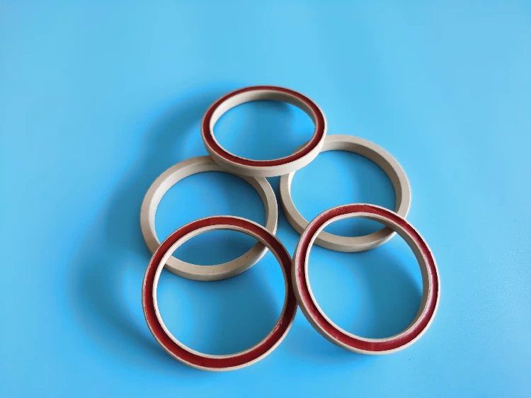 Front and reverse views of PTFE seal rings and red inserts supplied by IKSONIC