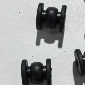 Side close-up of IKSONIC black gimbal vibration dampers showing the central body and retaining flanges.