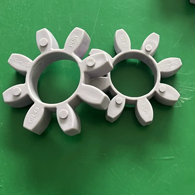 Grey GR42 and GR48 star insert examples with molded material markings on a green surface, supplied by IKSONIC