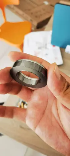 Graphite sealing ring held in a hand, showing its edge detail, from China supplier IKSONIC.