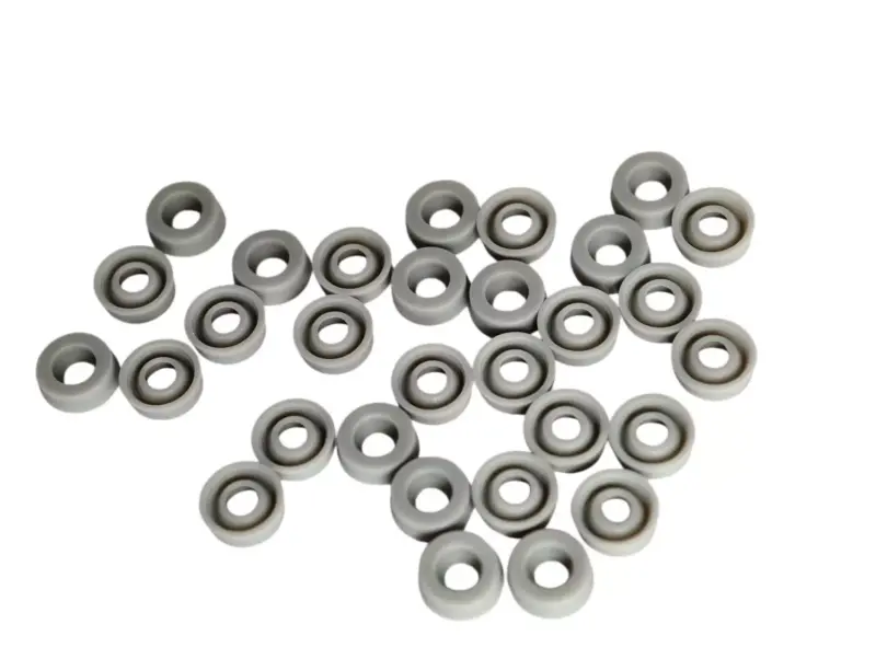 Gray dispensing cylinder seals arranged face up and face down, IKSONIC product view.