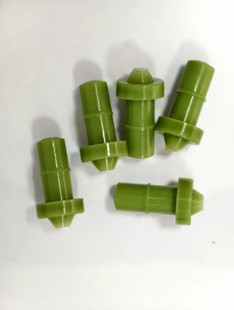 Five green rubber nozzles with flanged tips and cylindrical bodies, IKSONIC product detail.