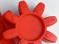 Close-up detail of a red coupling spider showing its recessed center, molded GS 28 marking and upper round bosses; lower arms are outside the crop; supplied by IKSONIC in China.