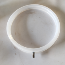 Top view of a translucent white IKSONIC inflatable seal ring and threaded air fitting.