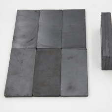 Dark rectangular IKSONIC magnetic ceramic liner tiles arranged flat with visible surface markings.