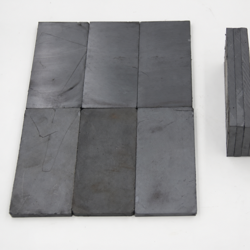 iksonic-magnetic-ceramic-liner-tiles-layout Dark rectangular IKSONIC magnetic ceramic liner tiles arranged flat with visible surface markings.