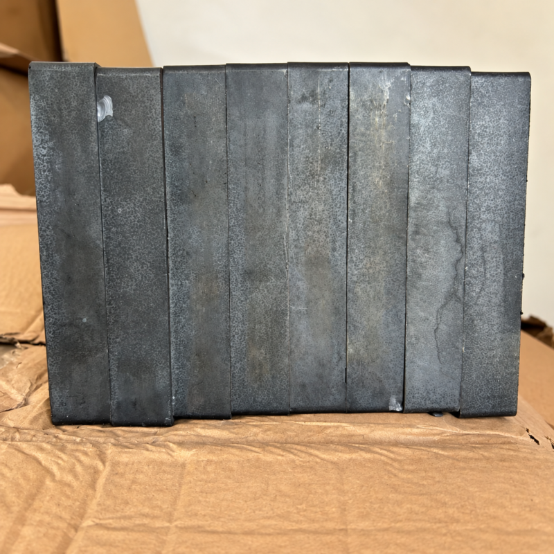 Dark rectangular IKSONIC ceramic liner tiles standing side by side on cardboard.