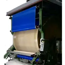 Blue and light-coloured mesh belts fitted to lamination equipment, illustrating an IKSONIC belt application.