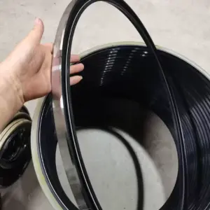 Large IKSONIC metal-cased rotary oil seal held by hand, with additional seals visible behind it.