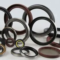 Assorted IKSONIC rotary oil seals arranged upright and flat, showing metal outer cases and black and brown sealing elements.