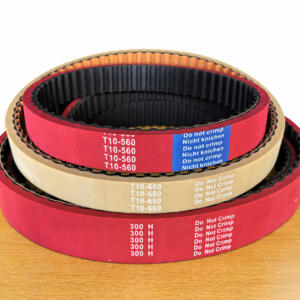 Stacked red and beige IKSONIC packaging-machine timing belts showing their inner teeth.