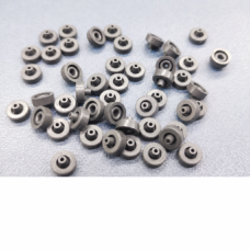 IKSONIC supplier photo of piezo dispensing valve seals arranged in multiple orientations on a textured surface.
