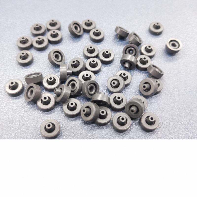 iksonic-piezo-dispensing-valve-seals-group-view-01 IKSONIC supplier photo of piezo dispensing valve seals arranged in multiple orientations on a textured surface.