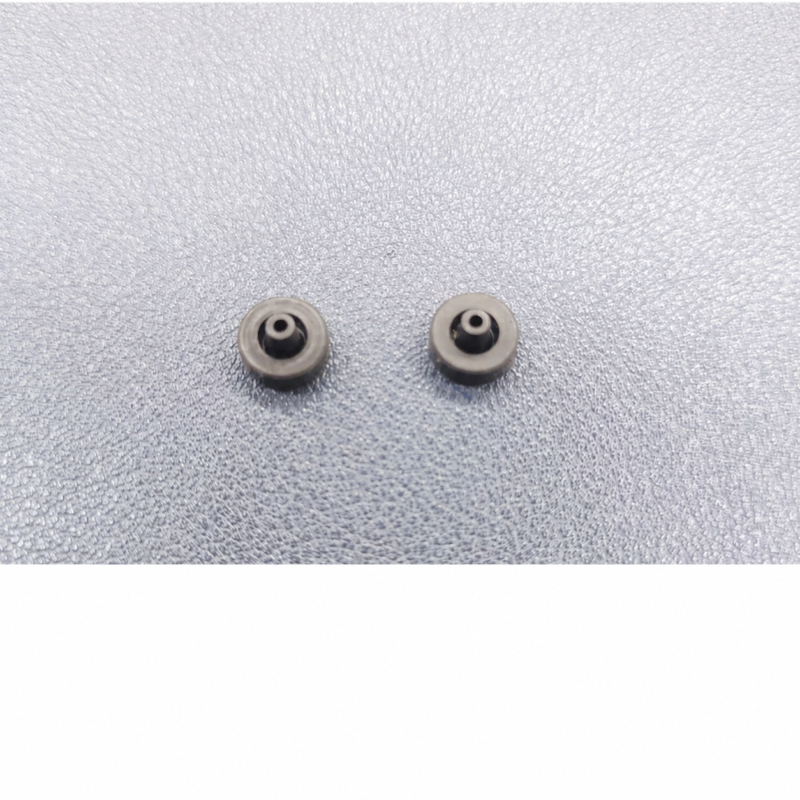 IKSONIC supplier photo showing two piezo dispensing valve seals with central bores on a textured surface.