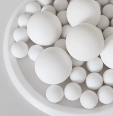 Assorted sizes of white PTFE balls in a tray, supplied by IKSONIC