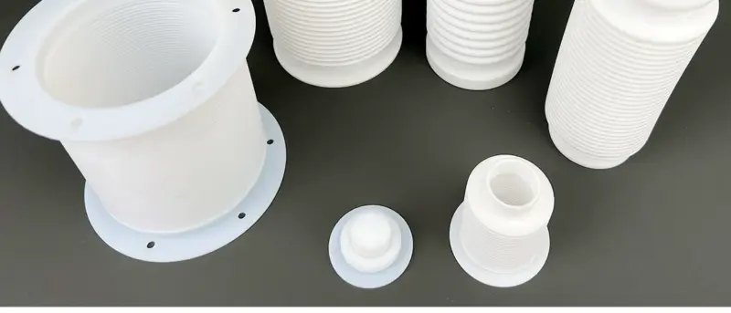 PTFE bellows viewed from above, showing open bores, corrugated walls and flanged ends; supplied by IKSONIC in China.
