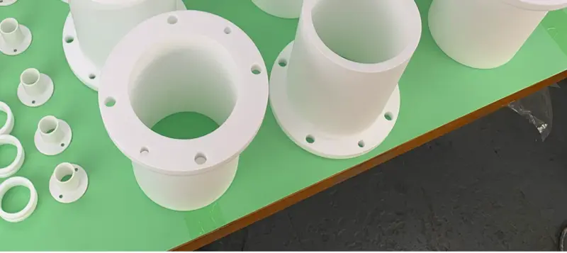 PTFE flanged sleeves showing the open bore and circular mounting-hole pattern; supplied by IKSONIC in China.